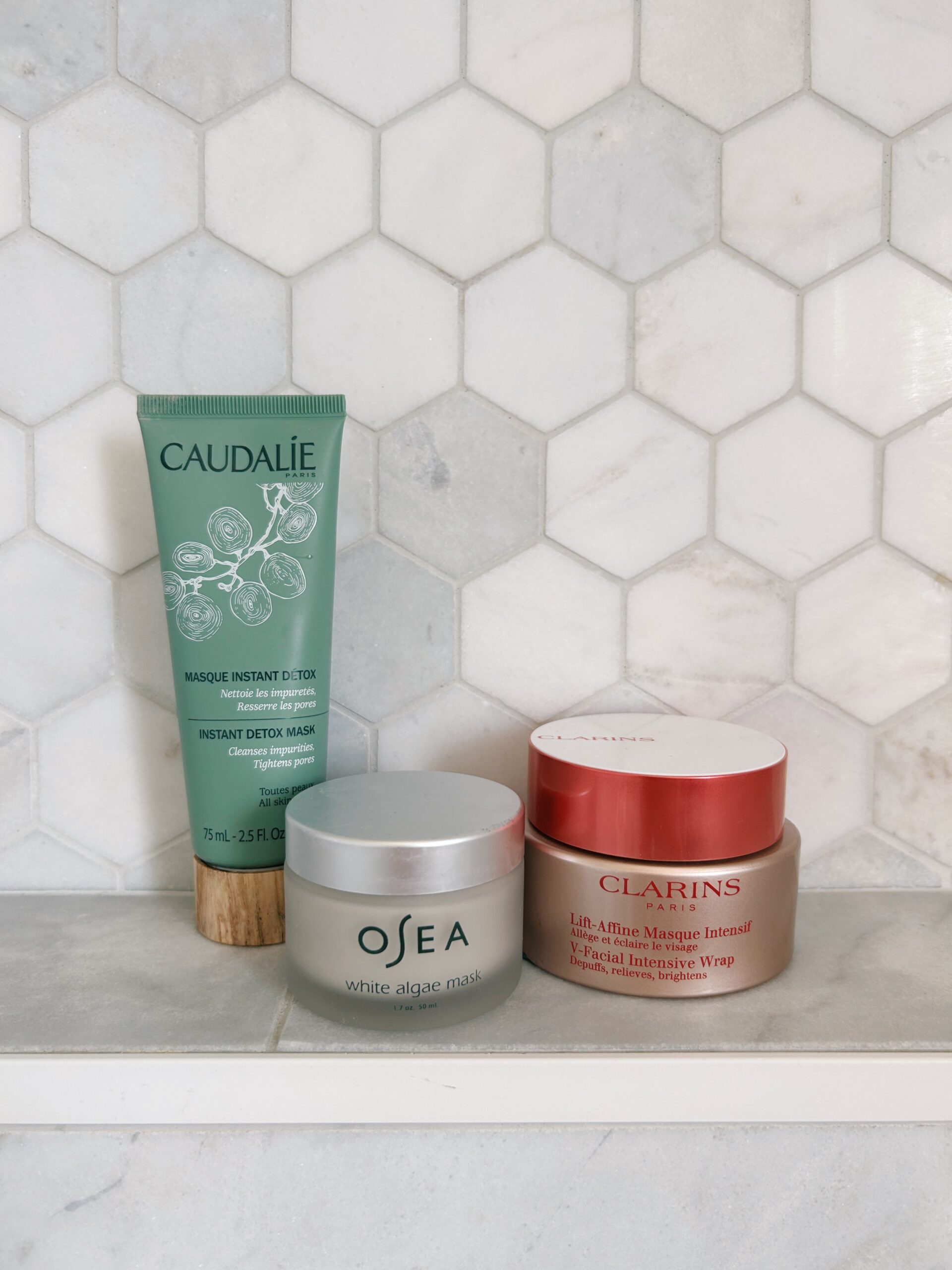 three beauty products on a shower shelf