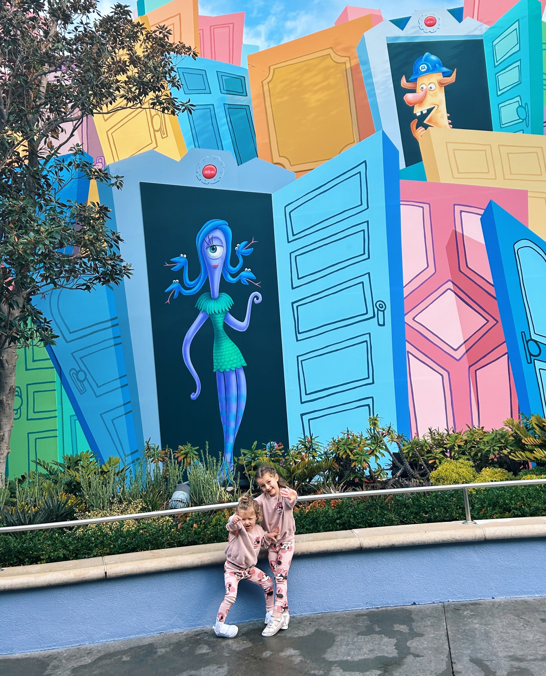 two kids photographed near a mural