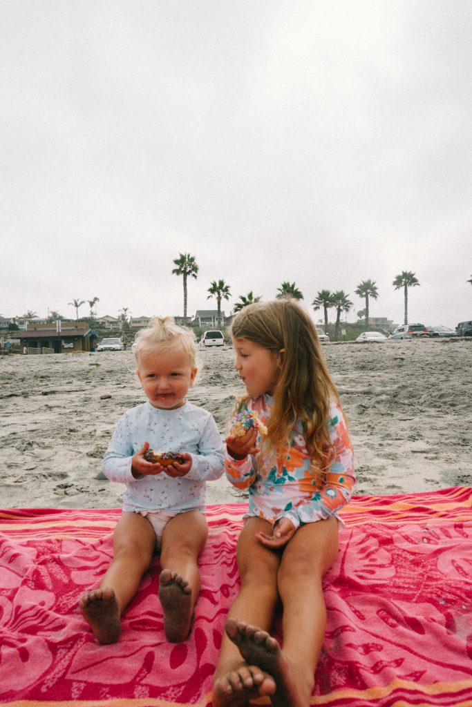 two kids eating at the beach