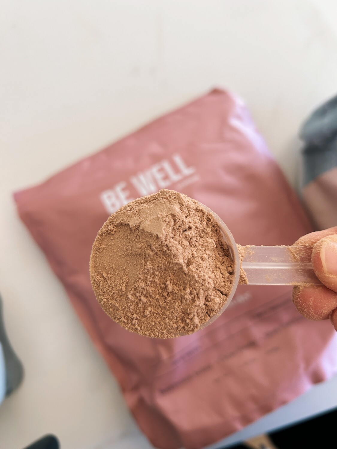 scoop of chocolate protein powder | Be Well By Kelly Protein Powder Review