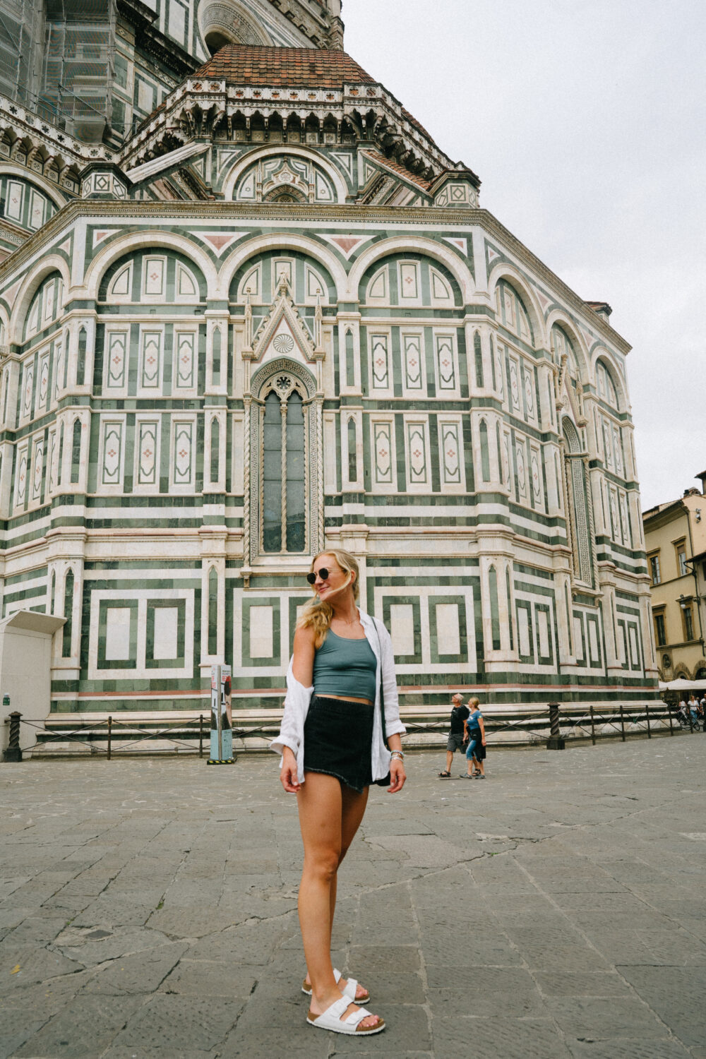 woman exploring Italy while wearing a black skort, tank top, and white Birkenstock 
