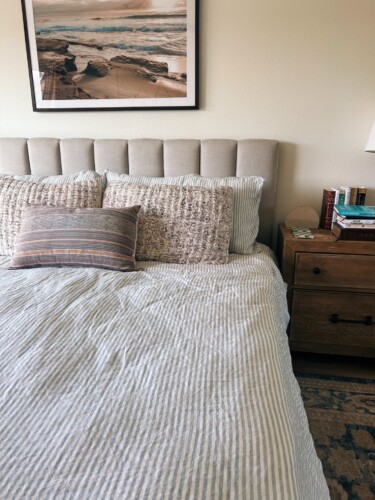 quince striped duvet on a bed with a landcsape photo