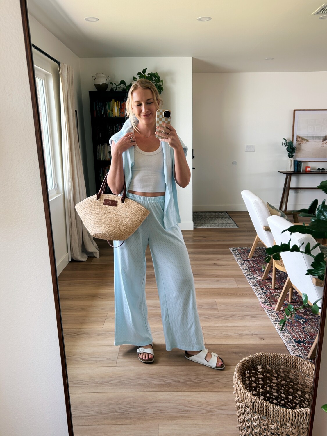 Ruth Nuss wearing light blue pointelle pants with a white tank and a Sézane basket bag
