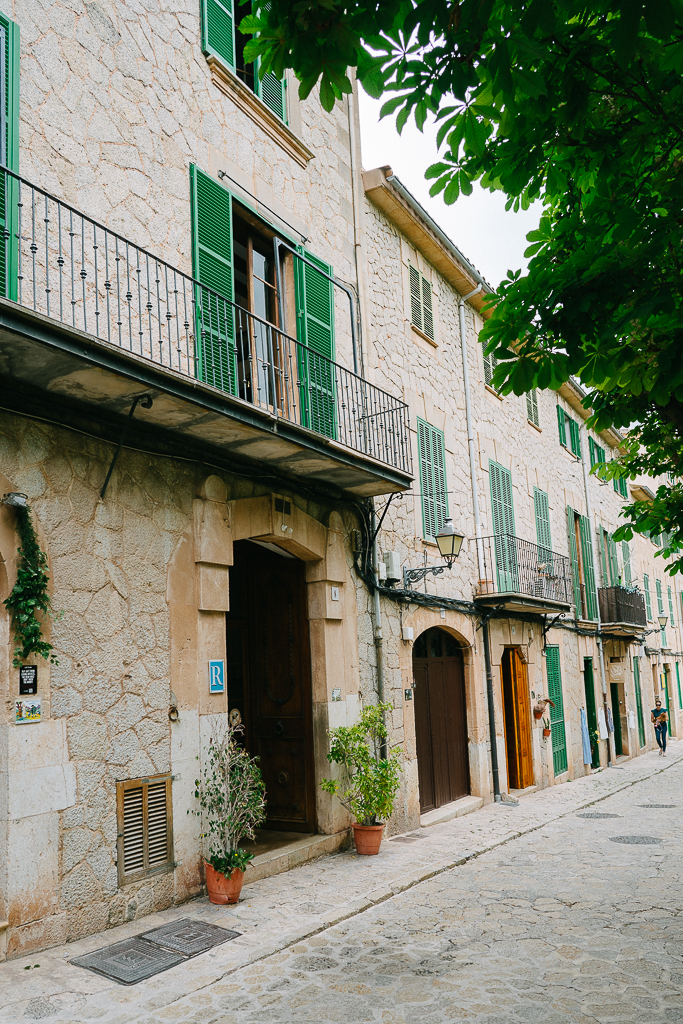 green shutters on an old stone building in Valldemossa