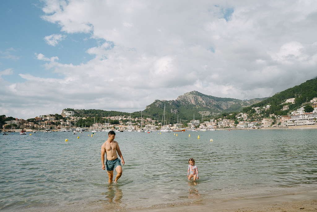 tyler nuss and his daughter in the water on the beach at port de soller in their tips for visiting mallorca with kids