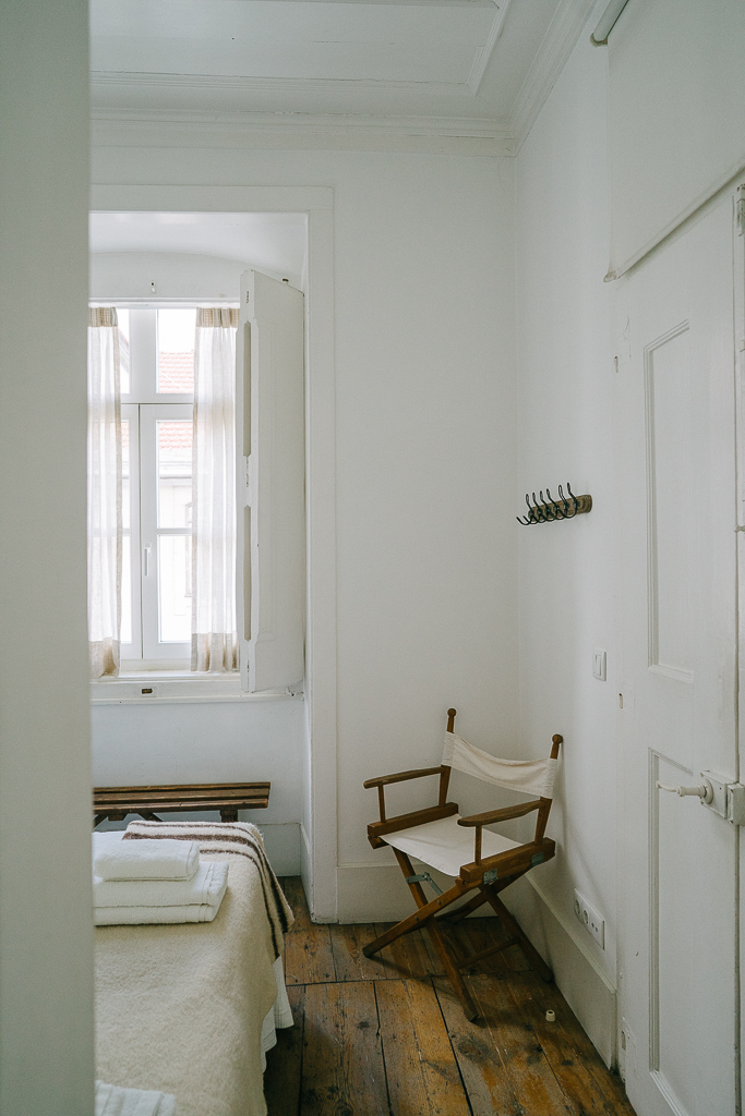 chair next to a window in a bedroom in a baixa house apartment in lisbon