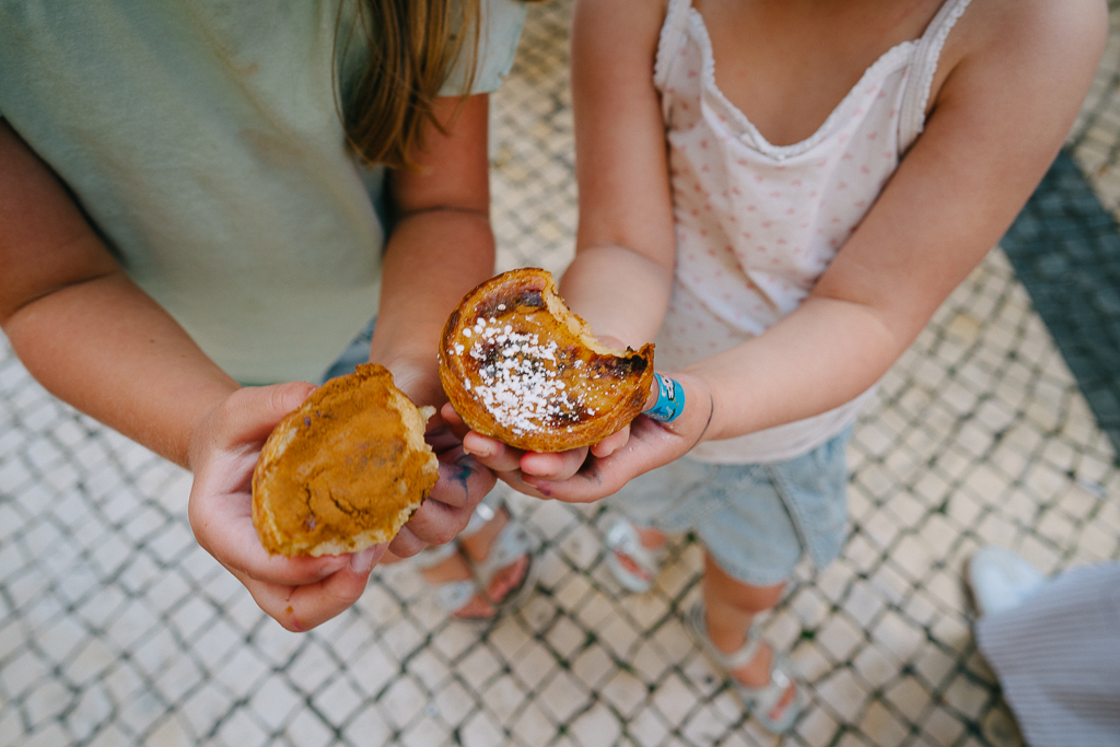 two girls holding pastais da nata in a 3 day lisbon itinerary