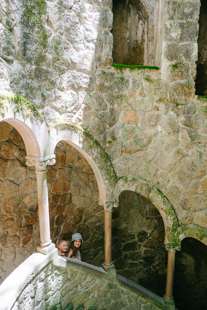 two girls walking in the initiation well in quinta da regaleira in sintra