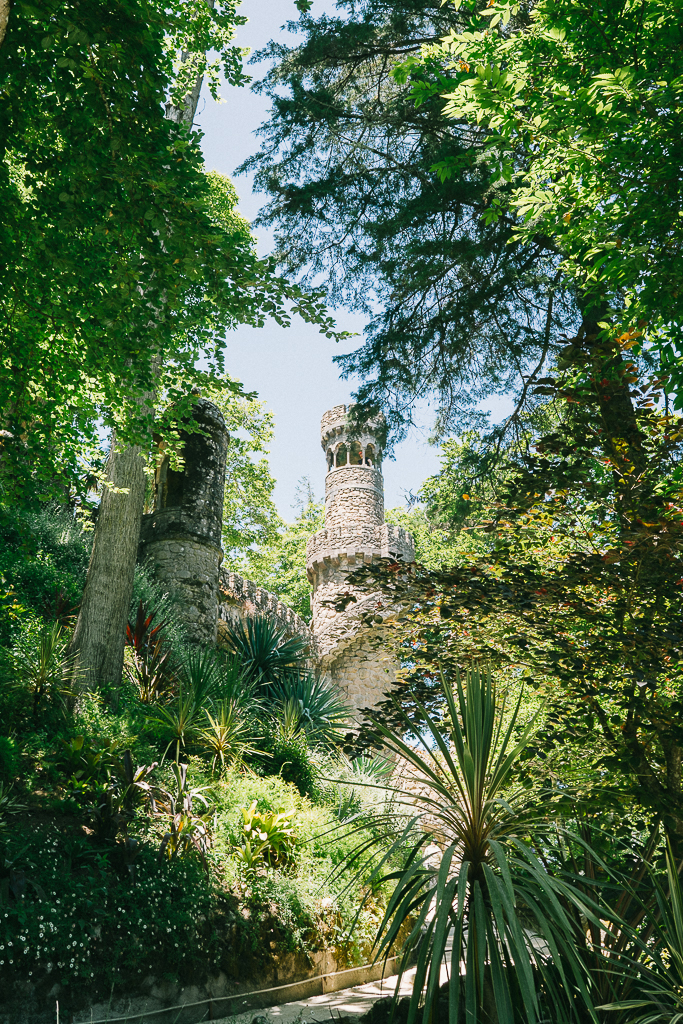 a tower between some trees in quinta da regaleira in sintra 