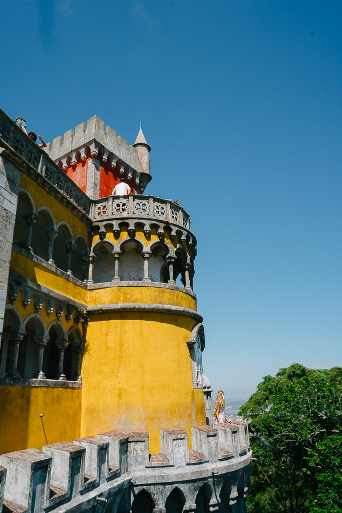 a yellow and red tower of pena palace in sintra portugal