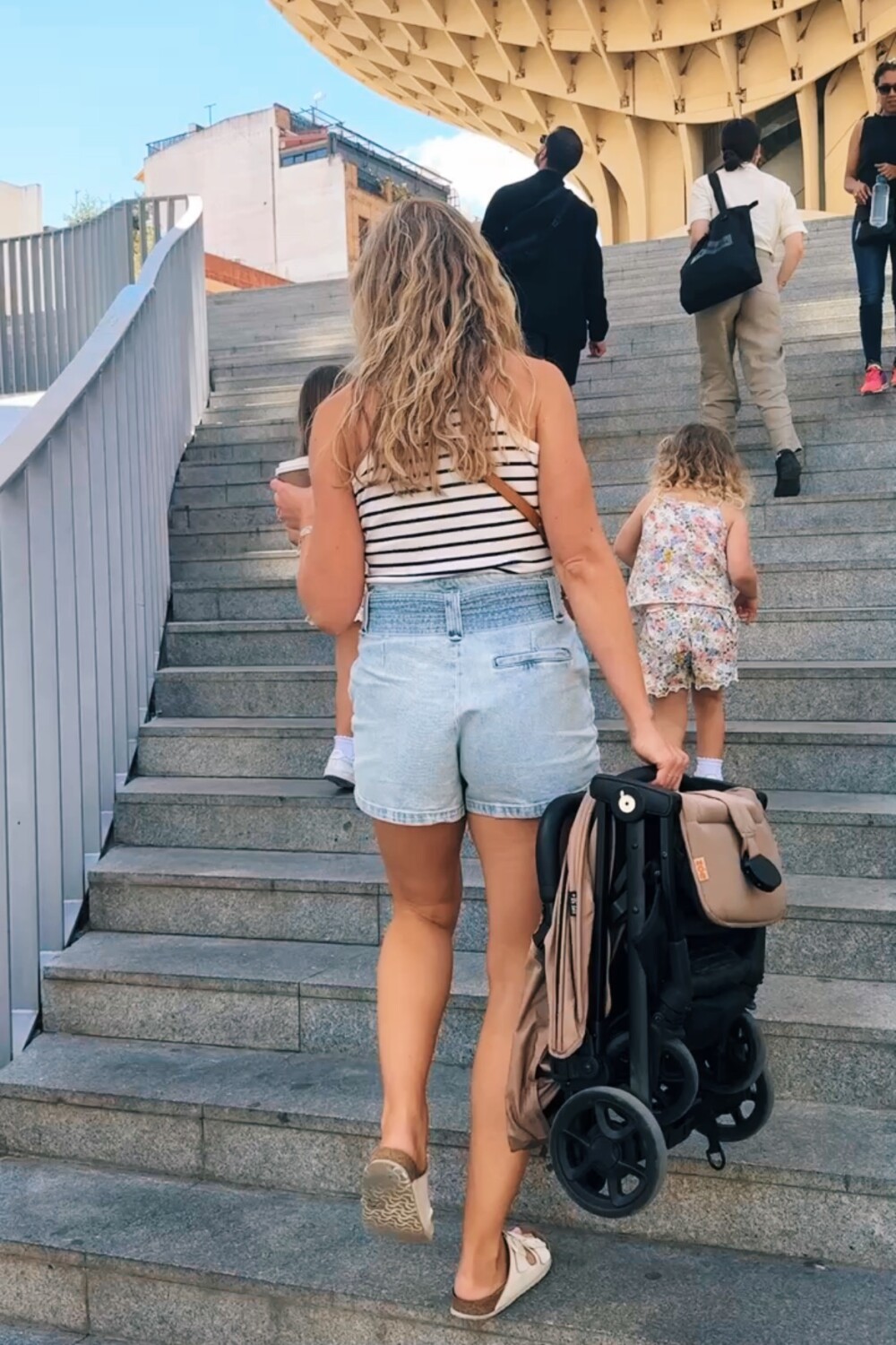 ruth nuss carrying the zoe travel stroller up some steps in sevilla