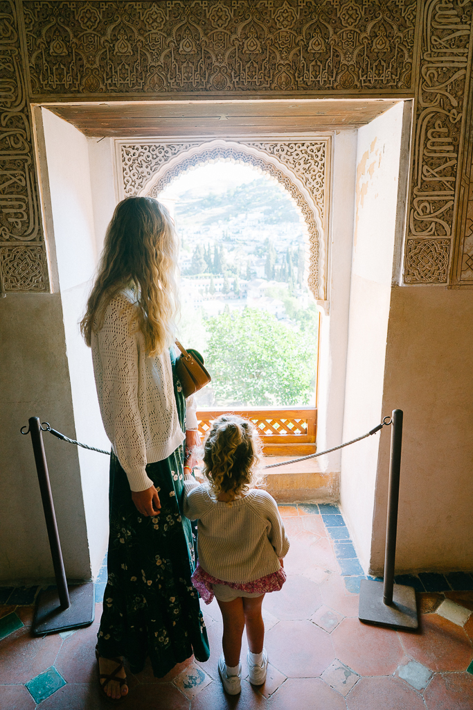 ruth nuss and her daughter standing in front a window in the nasrid palaces in granada spain