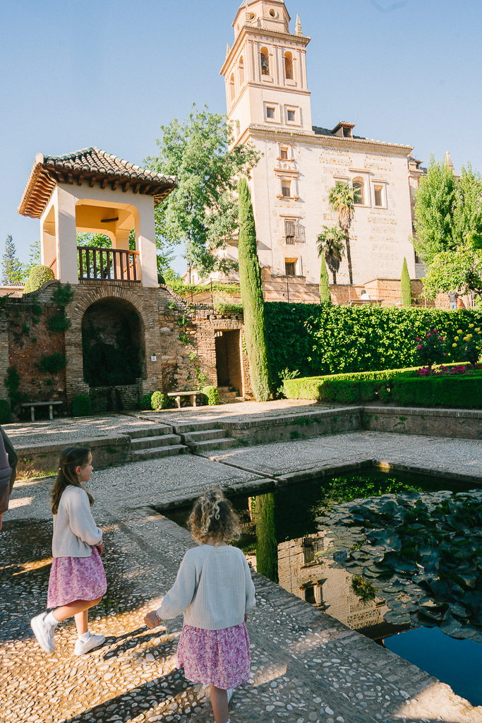 two girls looking at a pond at the alhambra in granada spain