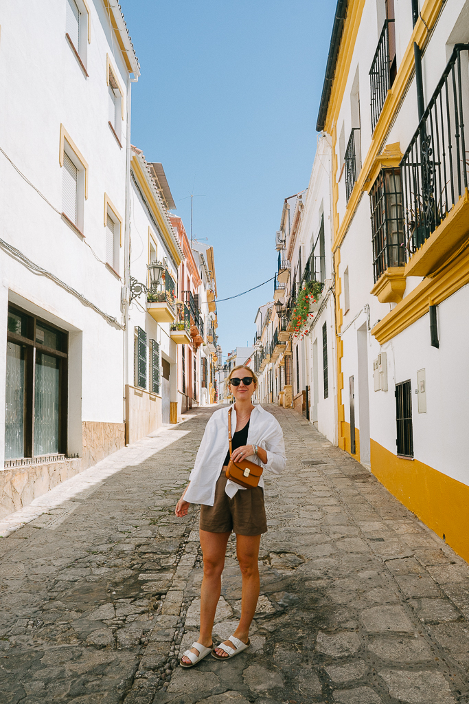 ruth nuss standing in a cobblestone alleyway in ronda spain