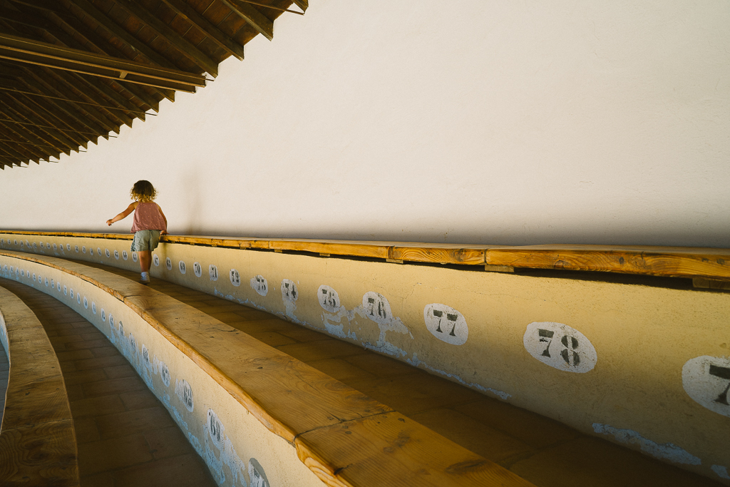 a girl walking in the bleachers of the ronda bull ring in southern spain