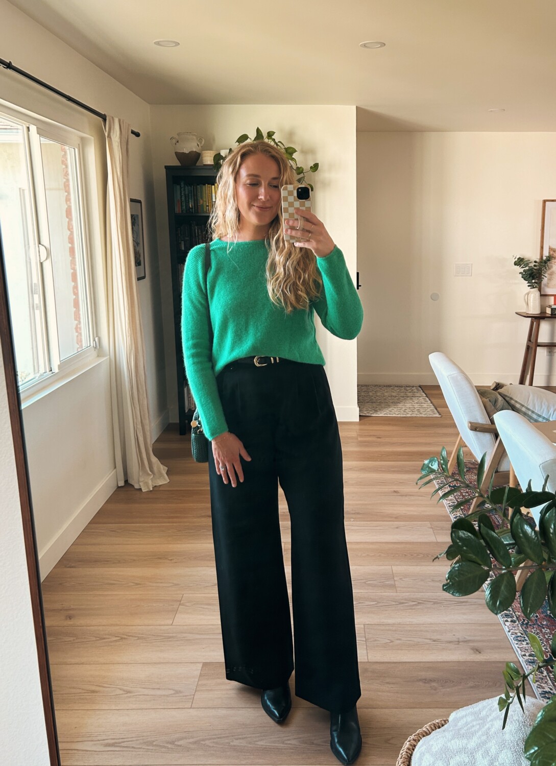 ruth nuss wearing a green sweater and black trousers for her sezane gaspard review