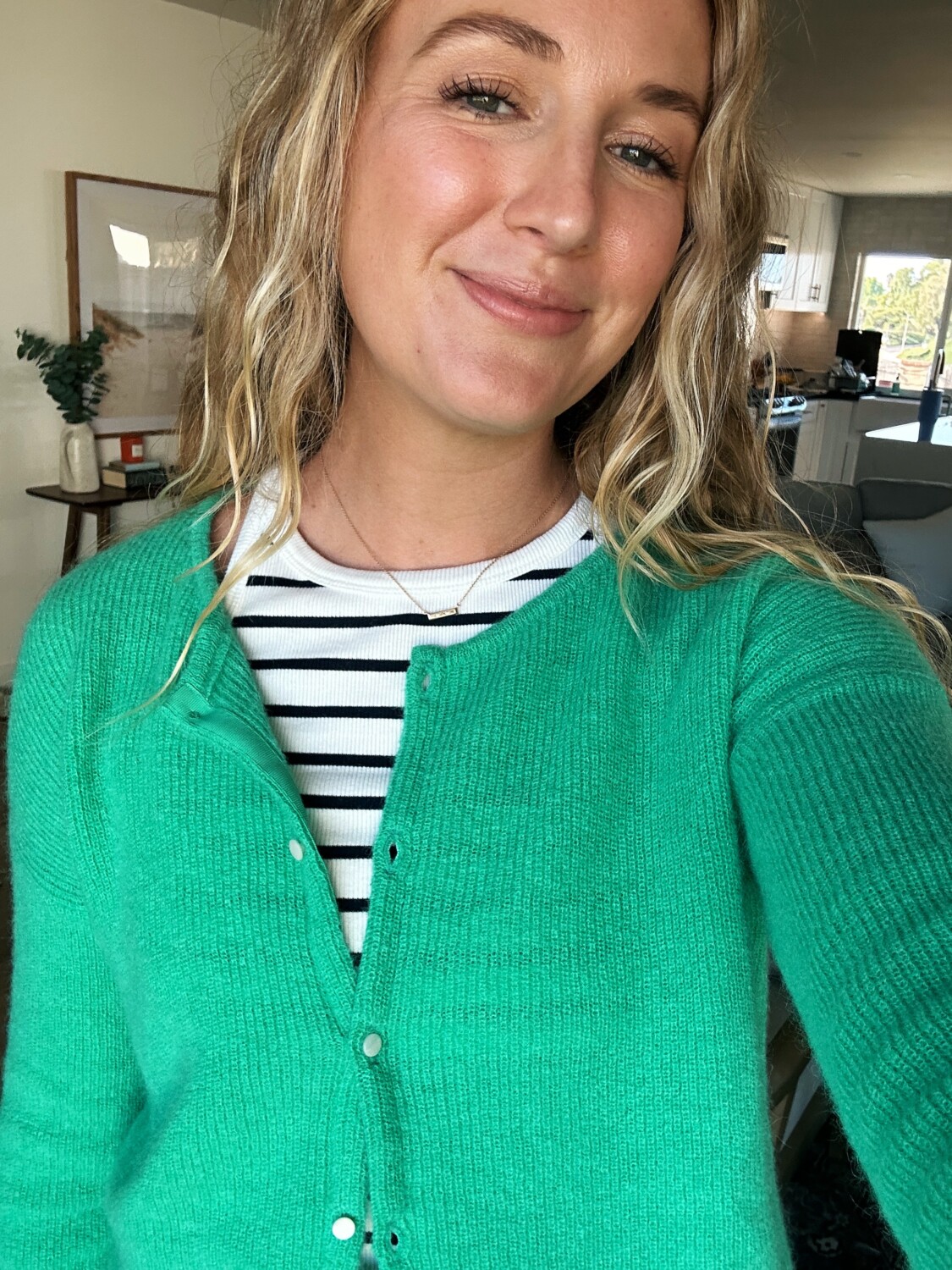 ruth nuss wearing a green cardigan over a striped tank top for her sézane gaspard review