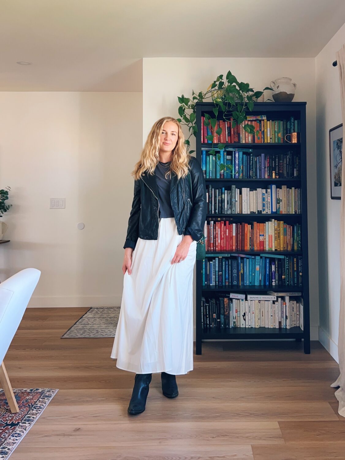 ruth nuss wearing a leather jacket and black boots with her maxi skirt for her white maxi skirt outfit ideas