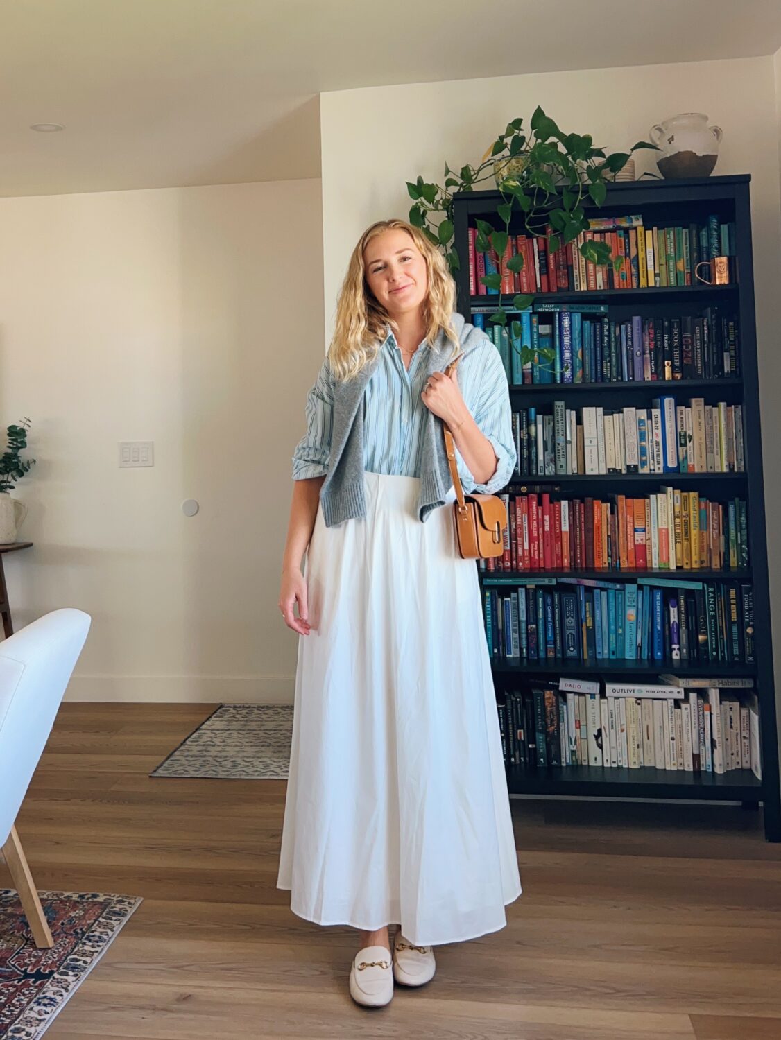 ruth nuss wearing a button-down shirt with her Sezane mini milo bag and her white maxi skirt from reformation