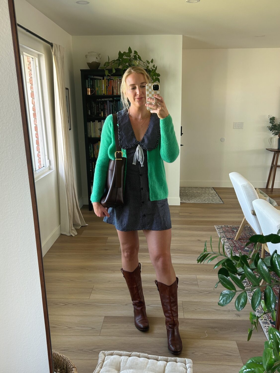 ruth nuss wearing a navy dress, green cardigan, and a madewell bucket tote