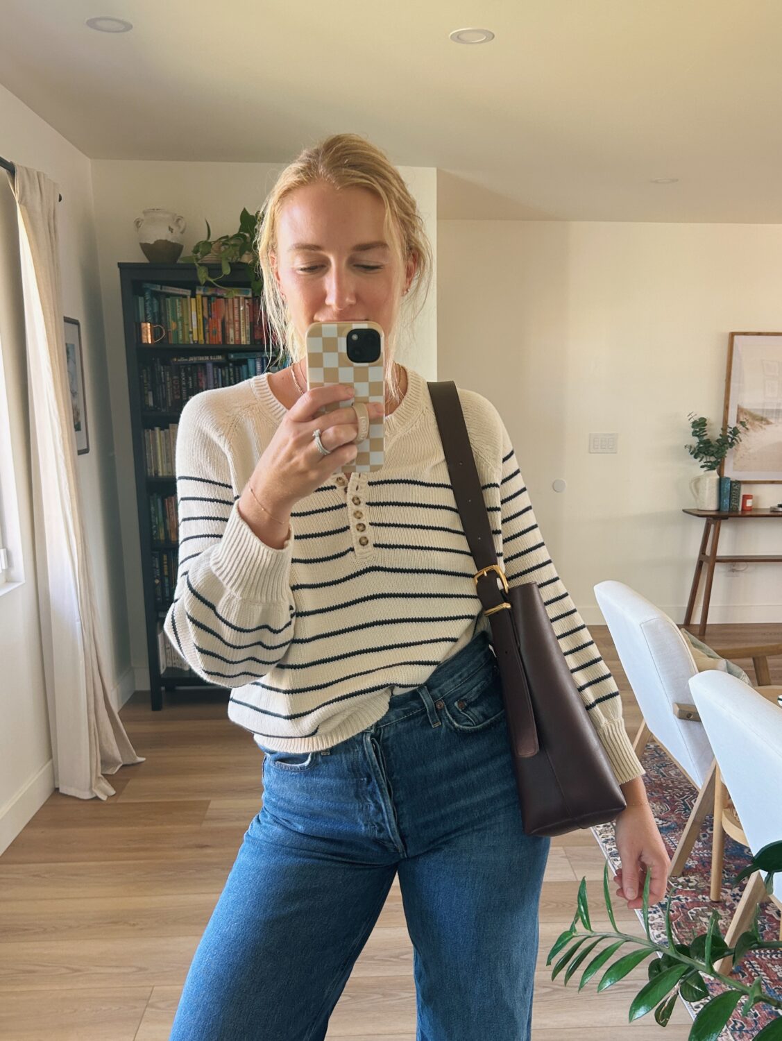 ruth nuss wearing a striped sweater and her madewell bucket bag