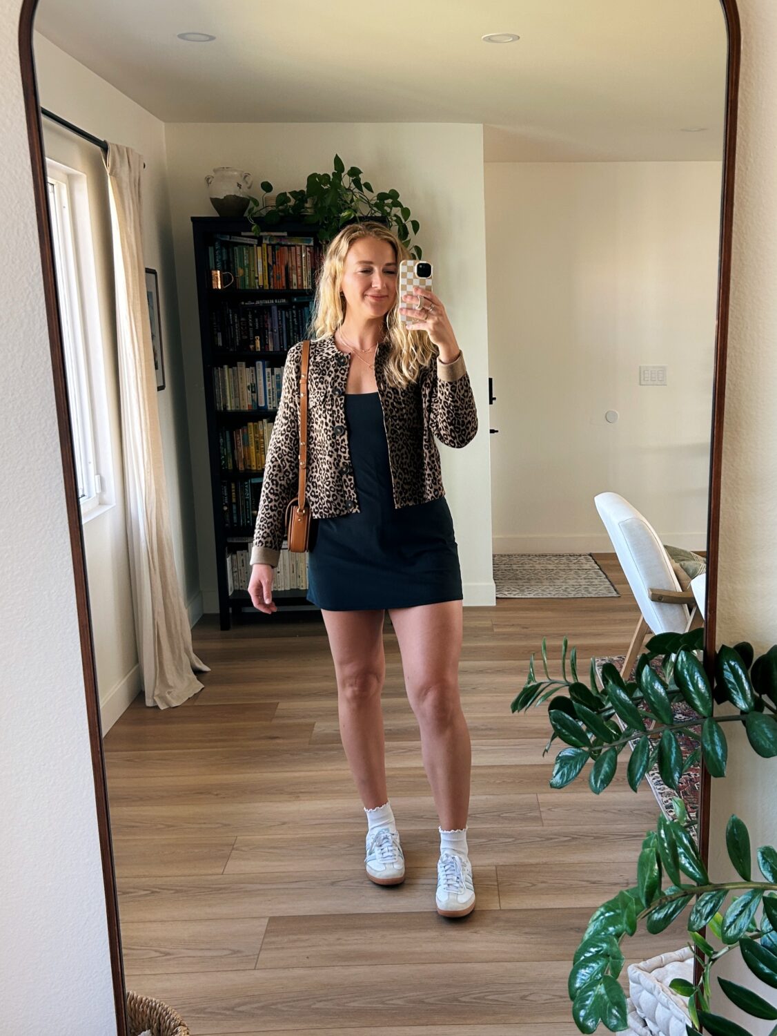 ruth nuss wearing the sezane betty cardigan and a black dress and sneakers