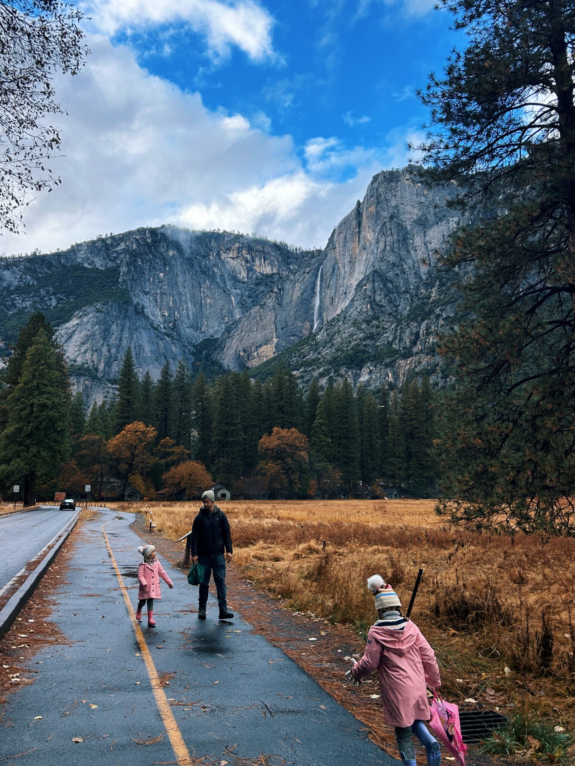 Tyler Nuss and his daughers walking in Yosemite Valley in front of Yosemite Falls