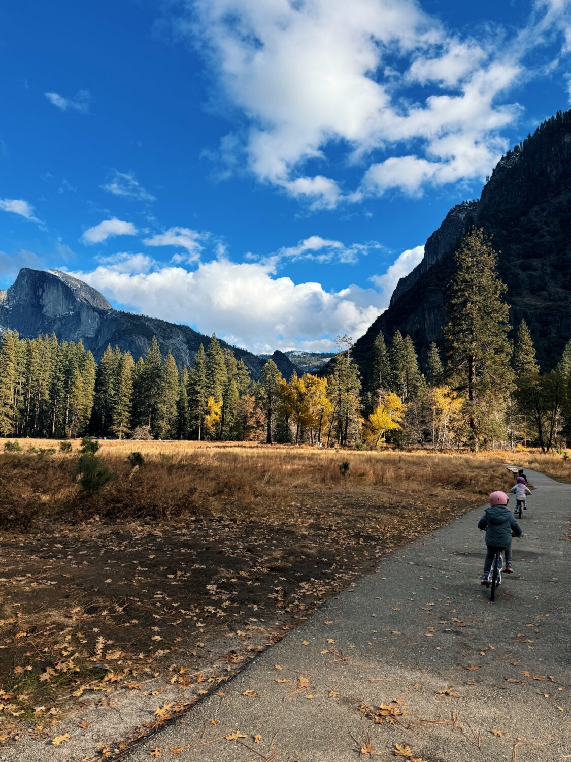 two girls riding a bike in yosemite in front of half dome