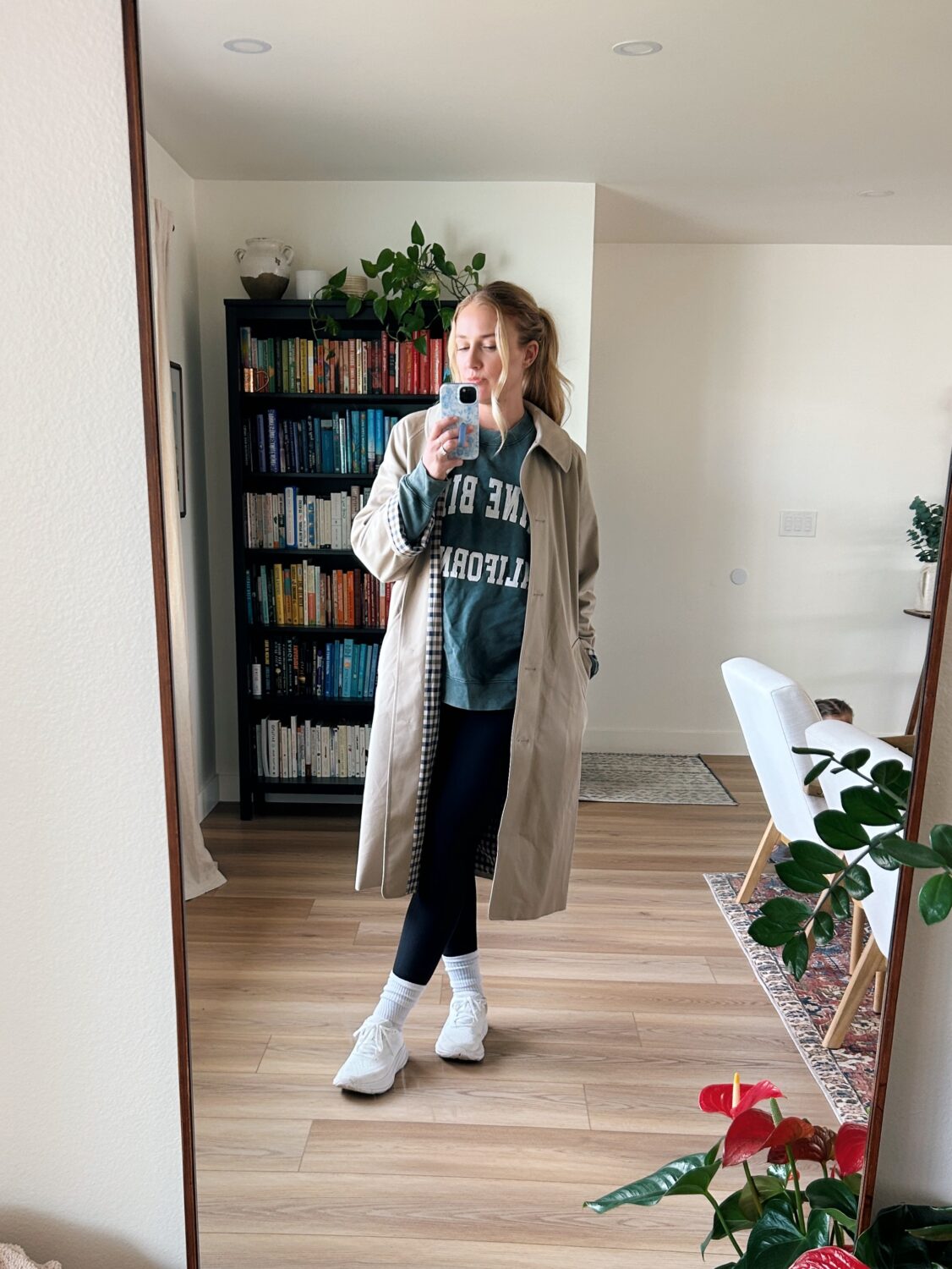 ruth nuss wearing the clyde trench with an anine bing sweatshirt, leggings, and running shoes