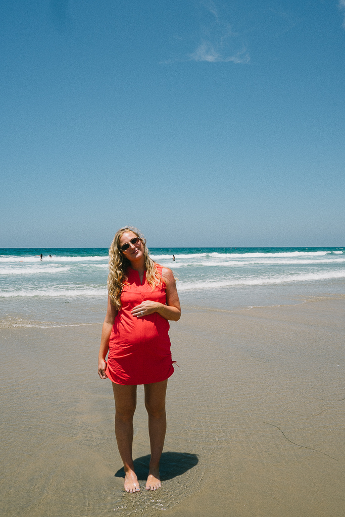 ruth nuss wearing a title nine dress on the beach at 25 weeks pregnant