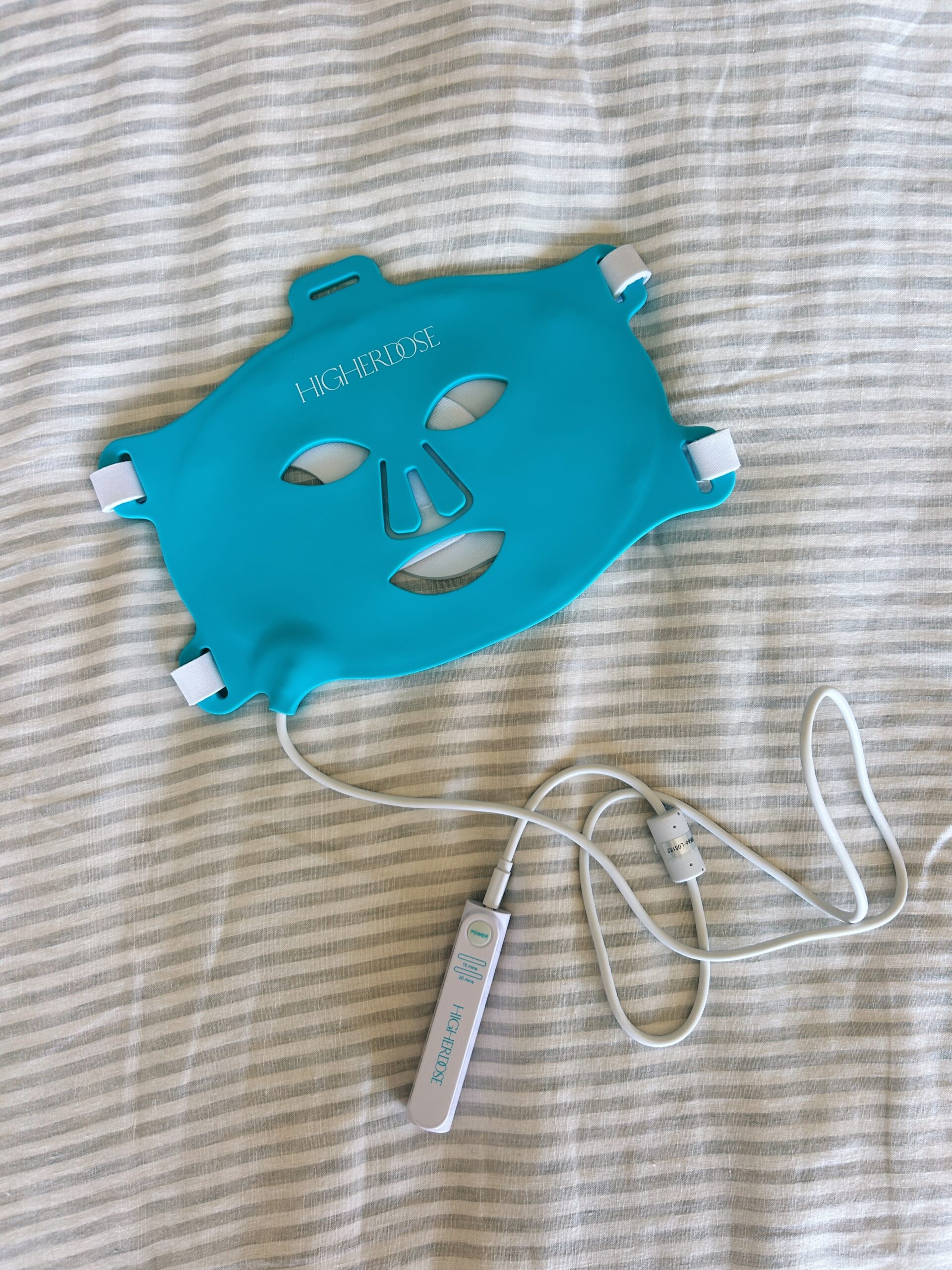 a red light mask on a bed for a higherdose red light therapy mask review