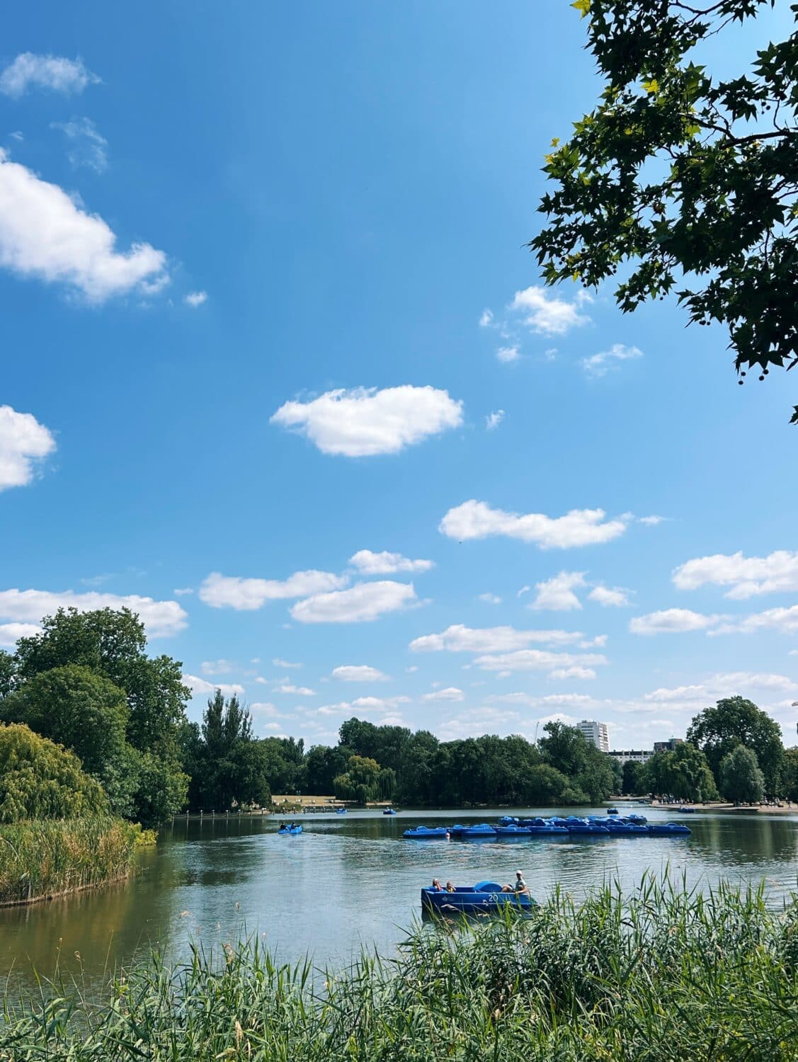 boating lake in regents park in london with a blue paddle boat and a blue sky
