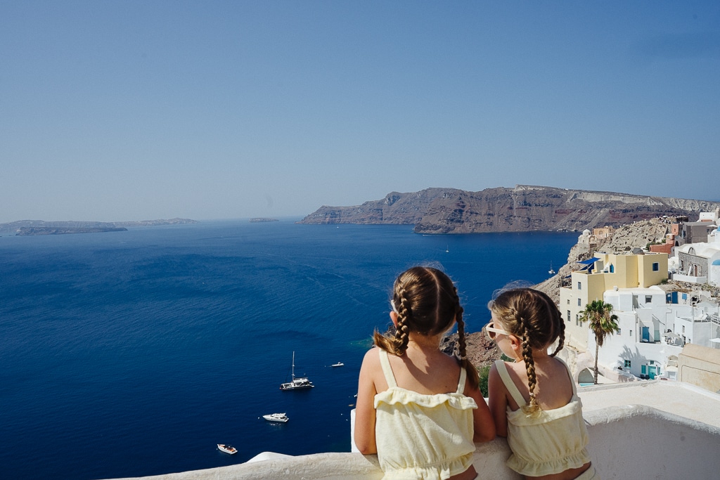 two children looking out over the caldera in santorini greece