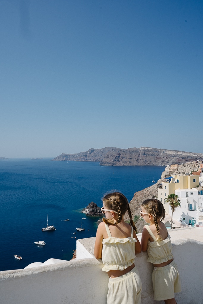 two girls looking at the view in oia santorini