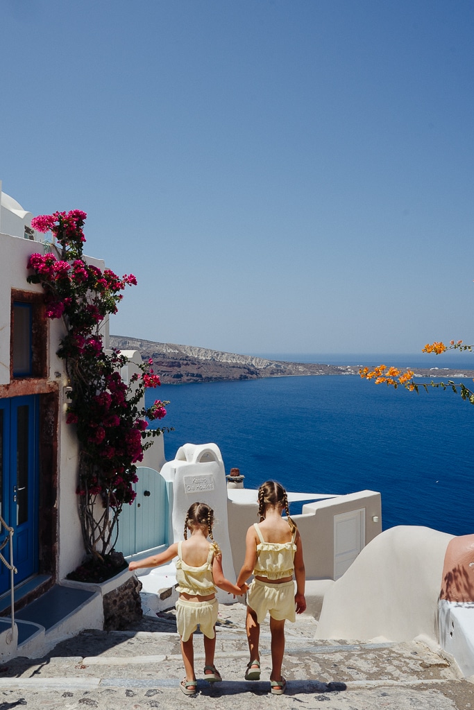 two children walking down a path in santorini greece for a guide for greece with kids