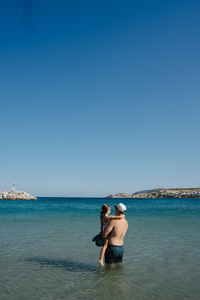 greek islands itinerary. tyler nuss and his daughter on a beach in paros greece